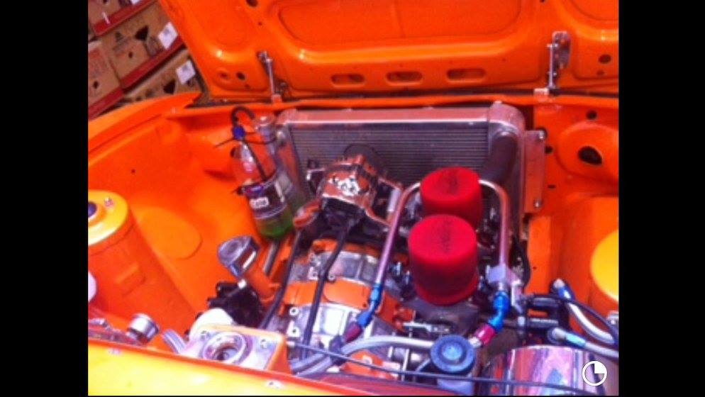 Rotary engine bay in an orange Mazda during mechanical repair